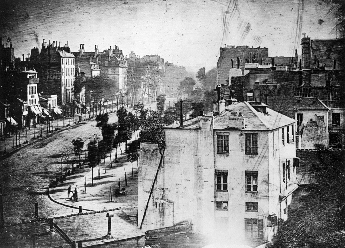 Un bulevar parisino visto desde arriba, con edificios a ambos lados y la calzada completamente vacía.